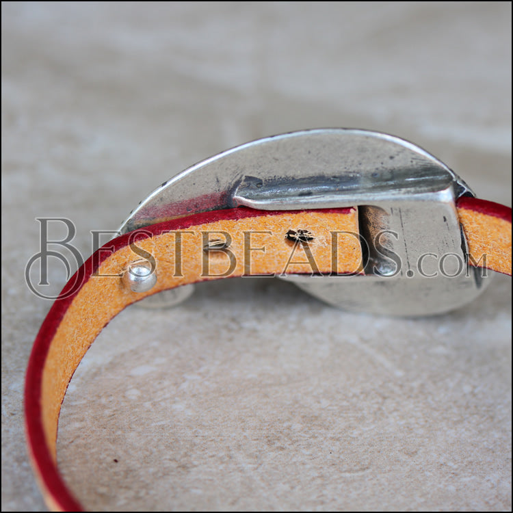 The back of the clasp - insert the post through a punched hole to secure it. You can leave the tail long or trim it.